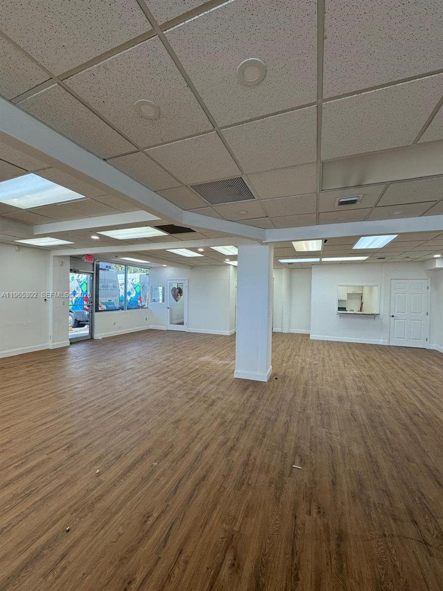 An empty commercial space features wood-look flooring, a drop ceiling with recessed lighting, and white walls — 4201 Palm Ave, Hialeah FL 33012, HIALEAH, FL
