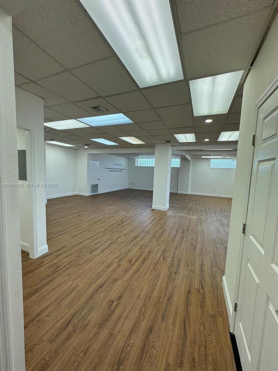 An empty commercial office space features wood-look flooring, a drop ceiling, and white walls — 4201 Palm Ave, Hialeah FL 33012, HIALEAH, FL