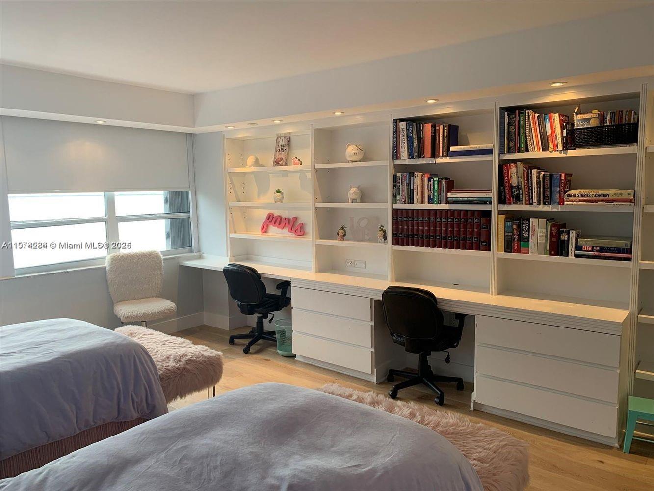 A bedroom features two beds, a long built-in desk with shelving, and light wood flooring — 2 Grove Isle Dr # B1507, Miami FL 33133, MIAMI, FL