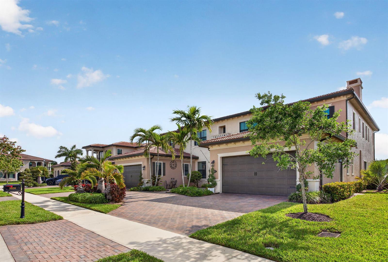 A two-story suburban house with a paved driveway, a two-car garage, and palm trees — 9080 Vista Way, Parkland FL 33076, PARKLAND, FL