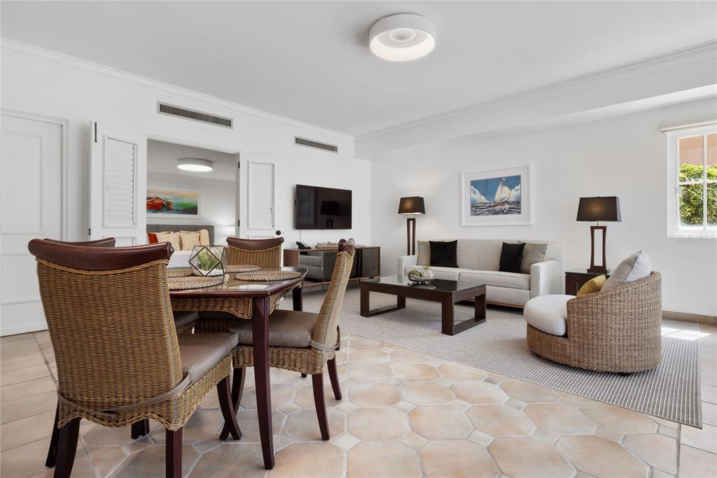 A living and dining area features wicker furniture, tile flooring, and a view into a bedroom — 1000 EL CONQUISTADOR AVE UNIT 5310, FAJARDO, PR