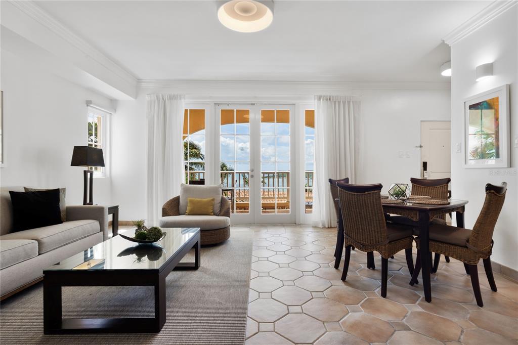 A living and dining area with tile floors, a glass coffee table, and balcony views — 1000 EL CONQUISTADOR AVE UNIT 5310, FAJARDO, PR