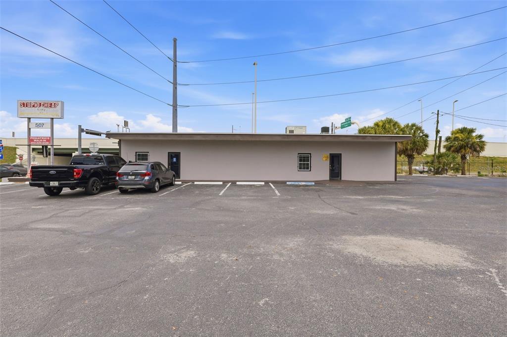 A single-story commercial building with a parking lot and a sign in the foreground — 507 E DR MARTIN LUTHER KING JR BOULEVARD, TAMPA, FL
