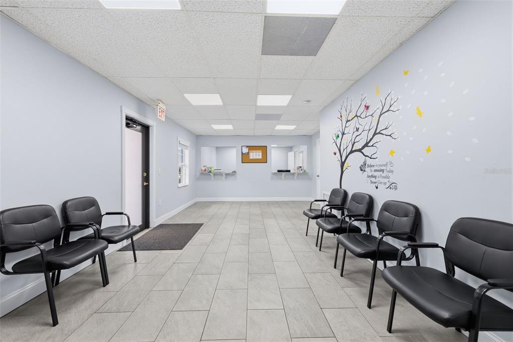 A waiting room features light gray walls, tile flooring, black chairs, and a wall decal — 507 E DR MARTIN LUTHER KING JR BOULEVARD, TAMPA, FL