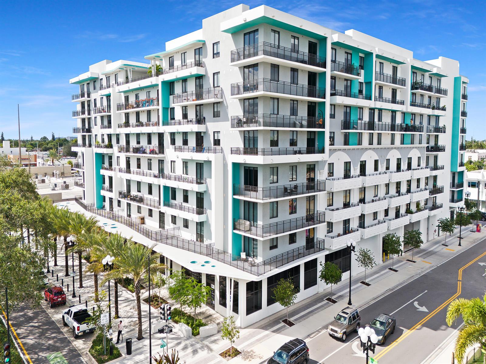 An exterior view of a modern multi-story apartment building with balconies and teal accents — 2001 Hollywood Boulevard, Hollywood FL 33020, HOLLYWOOD, FL
