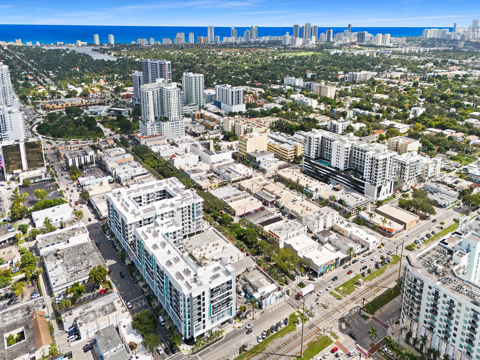 An aerial view of a dense urban neighborhood with modern apartment buildings and distant coastline — 2001 Hollywood Boulevard, Hollywood FL 33020, HOLLYWOOD, FL