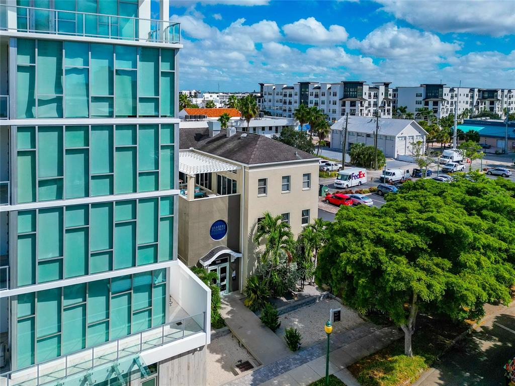 An exterior view shows a modern glass-paneled building next to a tan commercial structure — 1345 2ND STREET, SARASOTA, FL
