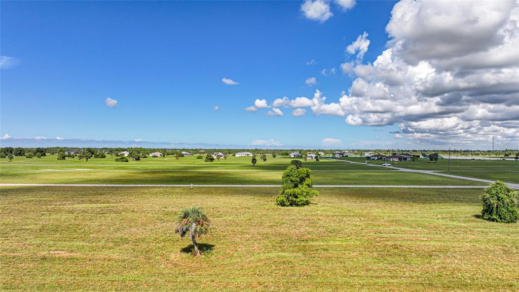 An aerial view of a large, flat, grassy field with scattered trees and distant houses — 37 WILLOW ROAD, PLACIDA, FL