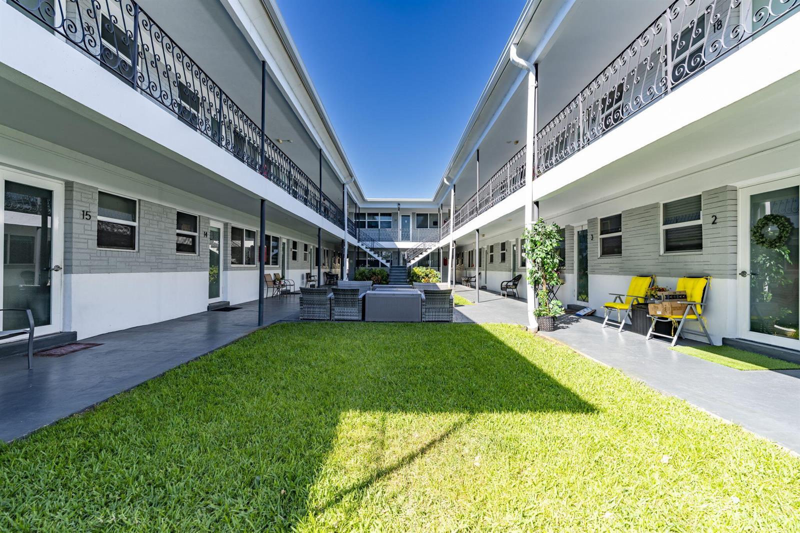 An outdoor courtyard with a central lawn is surrounded by a two-story apartment building — 302 Lake Osborne Drive # 5, FL 33461, FL