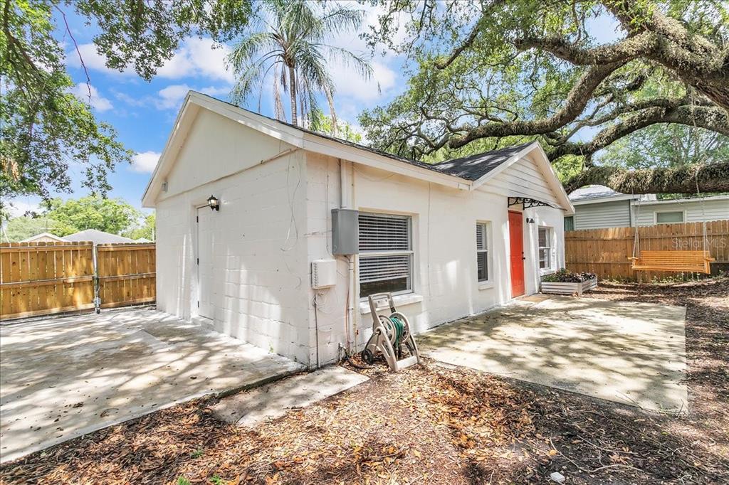 A white concrete block building with a red door and a concrete patio area — 6008 N TAMPA STREET UNIT 2, TAMPA, FL