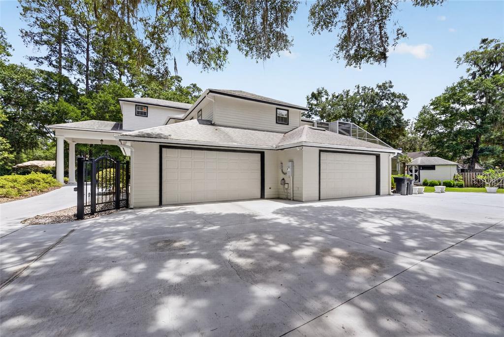 A two-story house with a large concrete driveway and two attached garage bays — 7815 NW 20TH LANE, GAINESVILLE, FL