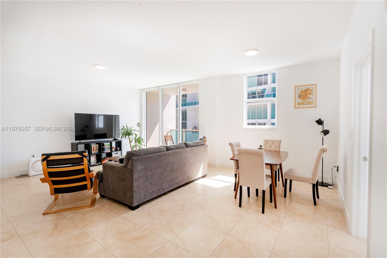 A living and dining area features tile floors, a gray sofa, and a dining set — 31 SE 5th St # 4121, Miami FL 33131, MIAMI, FL