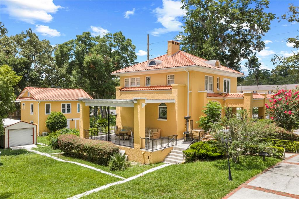 A yellow two-story house with a red tile roof and a covered patio area — 3610 E FORT KING STREET, OCALA, FL