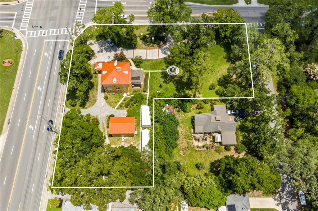 An aerial view shows two houses on a large, tree-filled lot near a road — 3610 E FORT KING STREET, OCALA, FL