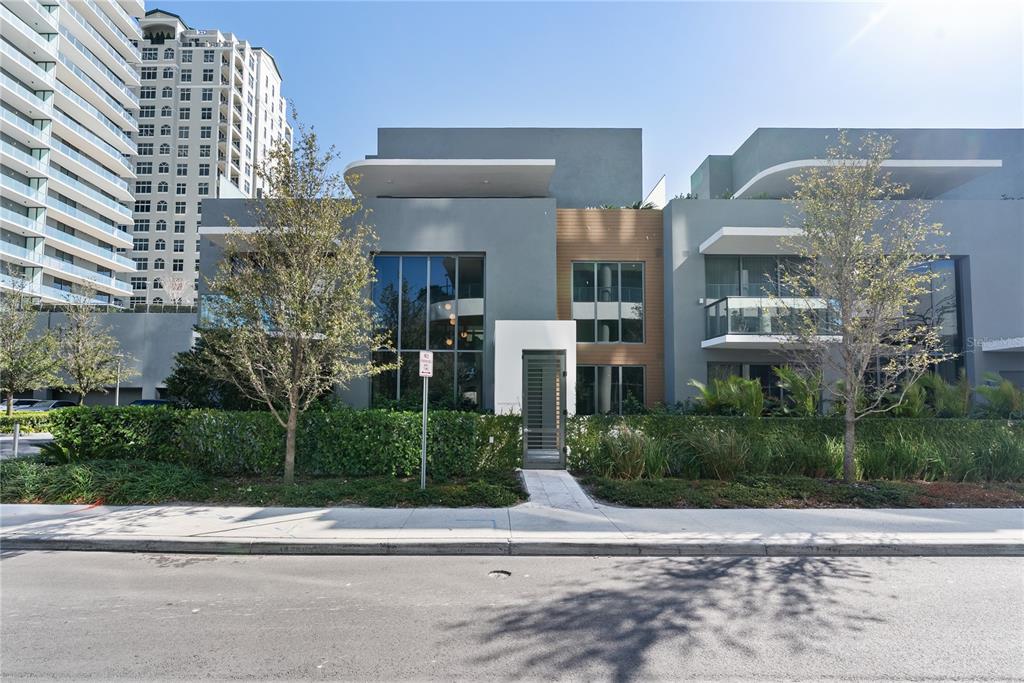 A modern two-story building with gray stucco, wood accents, and large glass windows — 3020 W SANTIAGO STREET UNIT 1, TAMPA, FL