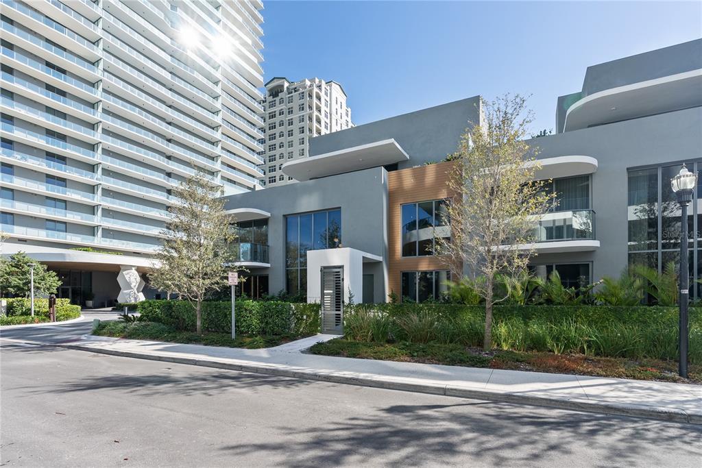 A modern multi-story building with gray walls, wood accents, and a large glass tower nearby — 3020 W SANTIAGO STREET UNIT 1, TAMPA, FL