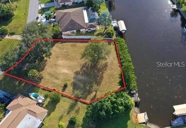 An aerial view shows a vacant, irregularly shaped waterfront lot outlined in red — 550 E TARPON BOULEVARD NW, PORT CHARLOTTE, FL