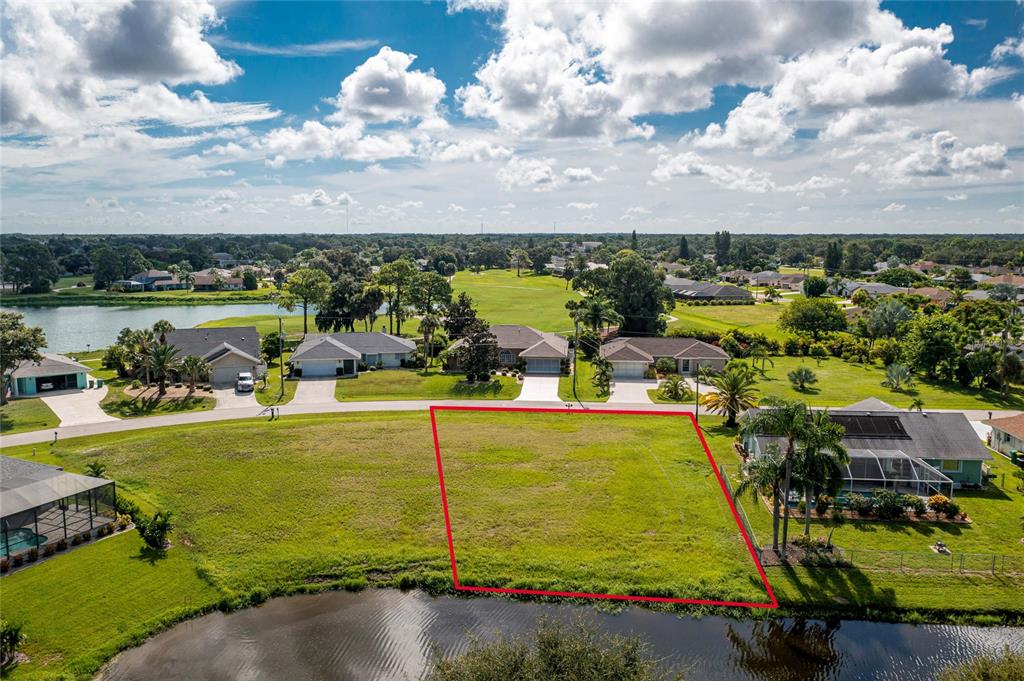An aerial view shows a vacant, rectangular residential lot bordering a small pond — 19 BUNKER TERRACE, ROTONDA WEST, FL