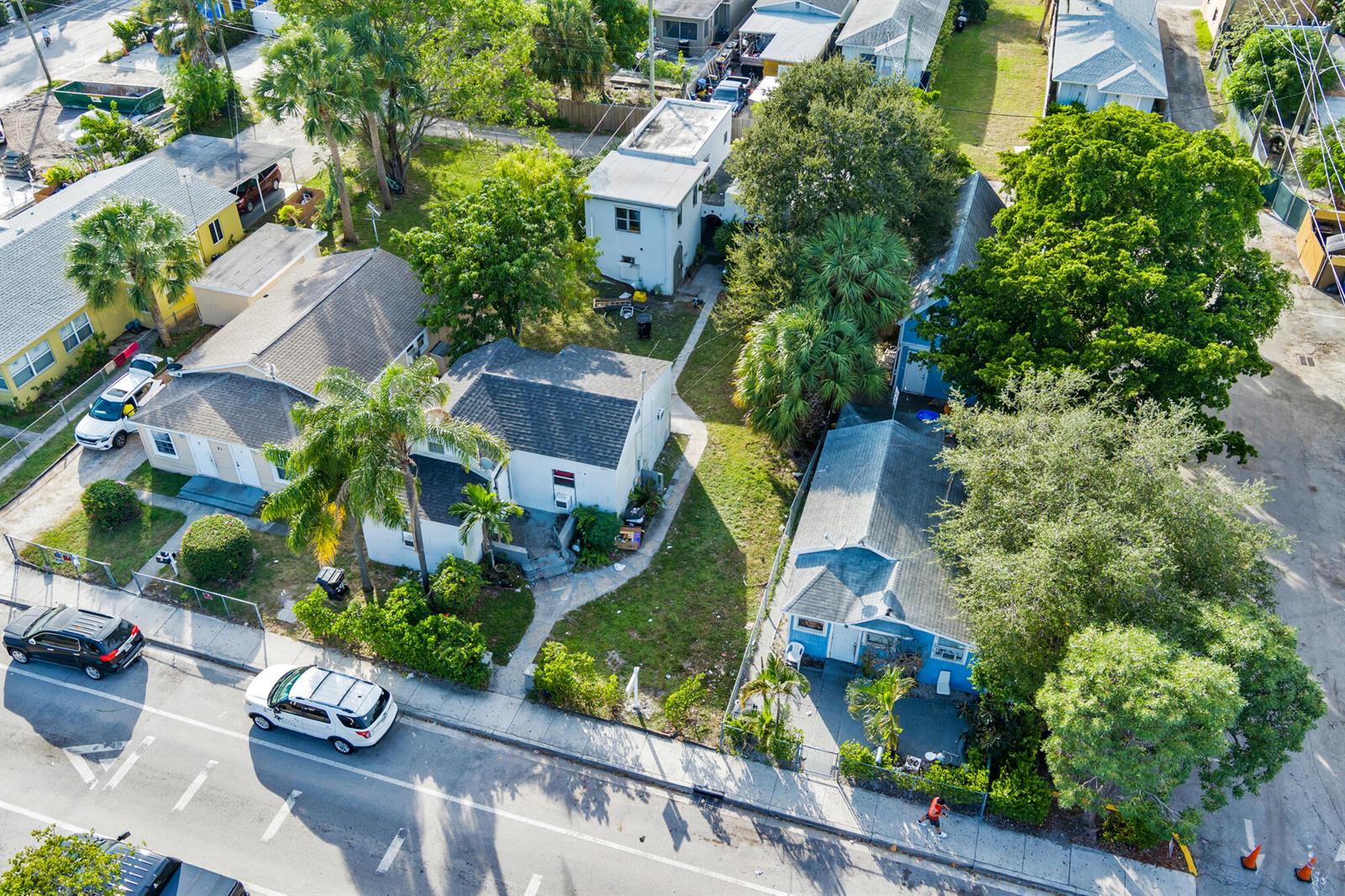 An aerial view shows several small residential houses with yards and parked cars — 19 S E Street, FL 33460, FL