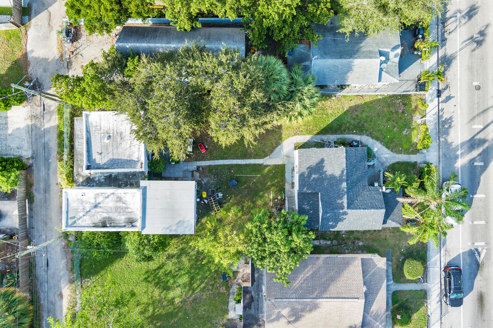 An aerial view shows two houses on a lot with trees, walkways, and parked cars — 19 S E Street, FL 33460, FL