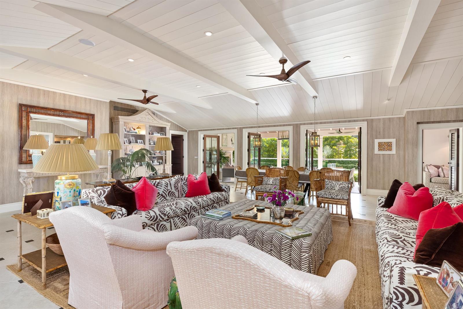 A spacious living room features vaulted ceilings, patterned furniture, and large glass doors opening outdoors — 258 List Road, Palm Beach FL 33480, PALM BEACH, FL
