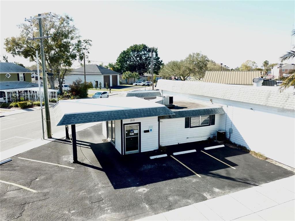 An elevated view of a small commercial building with a drive-thru canopy and parking lot — 212 MAIN STREET, AUBURNDALE, FL