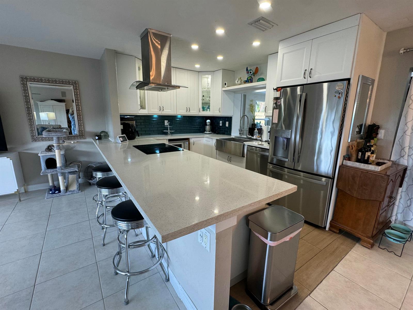 A kitchen features white cabinets, a quartz island with bar stools, and stainless steel appliances — 2099 S Conference Drive, Boca Raton FL 33486, BOCA RATON, FL