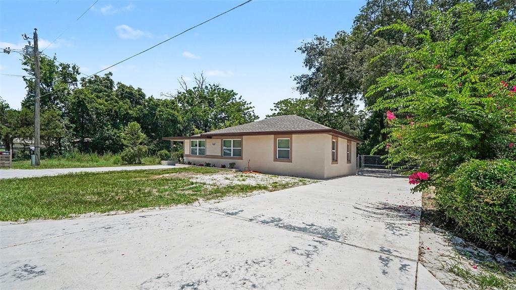 A beige, single-story house with a concrete driveway sits on a grassy lot — 1109 NW 14TH AVENUE, OCALA, FL