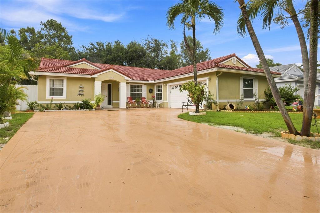 A single-story house with a red tile roof, tan stucco walls, and a concrete driveway — 13501 SW 17TH COURT, MIRAMAR, FL