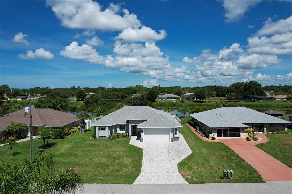 An aerial view of a suburban house with a gray roof and paved driveway — 7403 SNOW DRIVE, ENGLEWOOD, FL