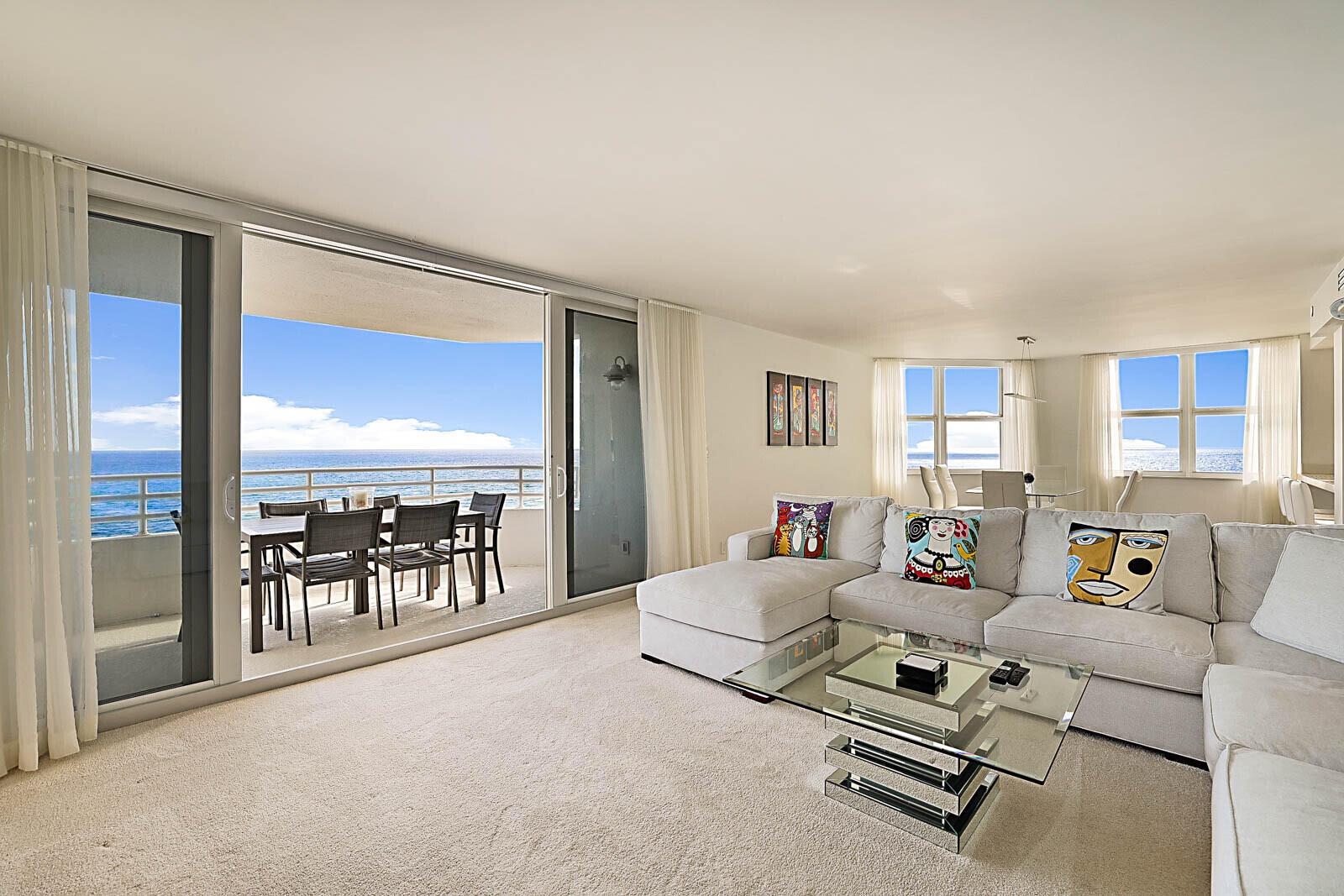 A living room with a sectional sofa, glass coffee table, and balcony overlooking the ocean — 3407 S Ocean Boulevard # 8a, Highland Beach FL 33487, HIGHLAND BEACH, FL