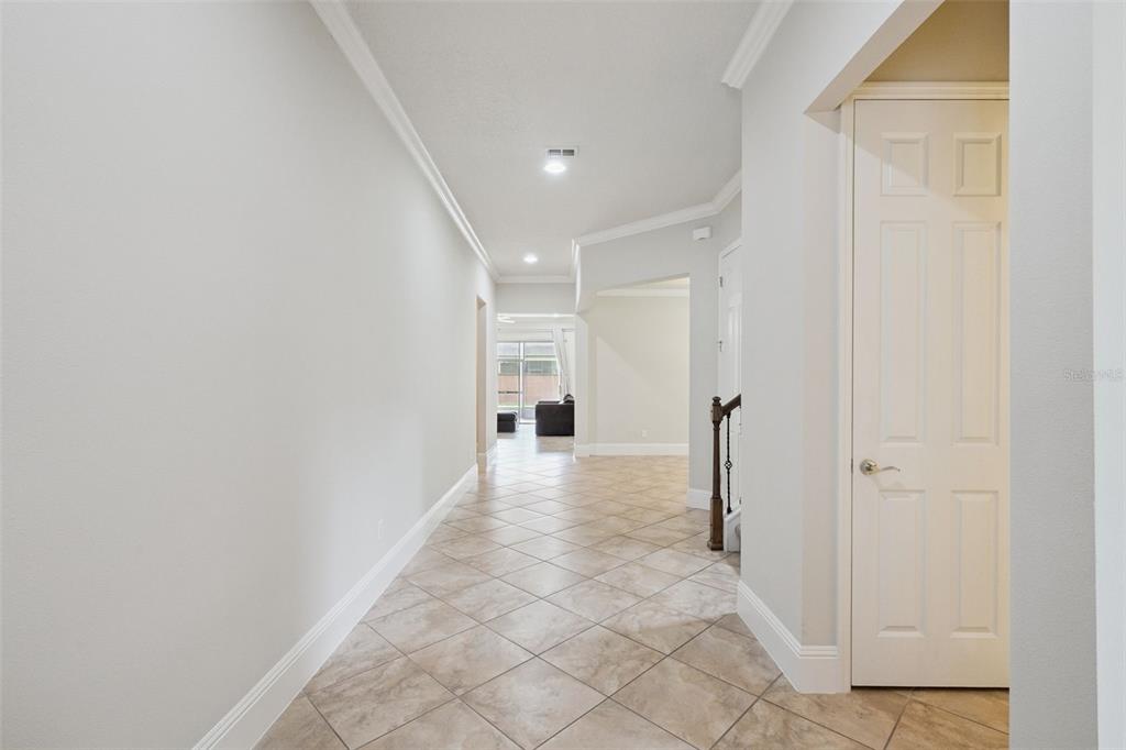 A tiled hallway leads toward a living area with a staircase on the right — 9447 PRINCE HARRY DRIVE, ORLANDO, FL
