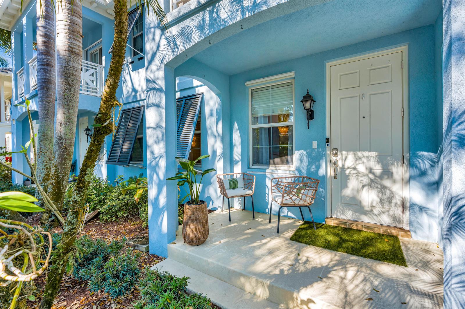 A light blue house exterior features a small front porch with two chairs and plants — 3032 W Community Drive, Jupiter FL 33458, JUPITER, FL