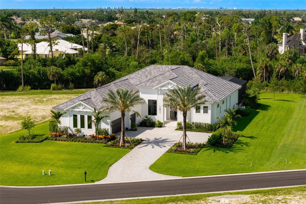 An aerial view of a modern white single-story house with a gray tiled roof — 15850 HAMPTON VIEW COURT, FORT MYERS, FL