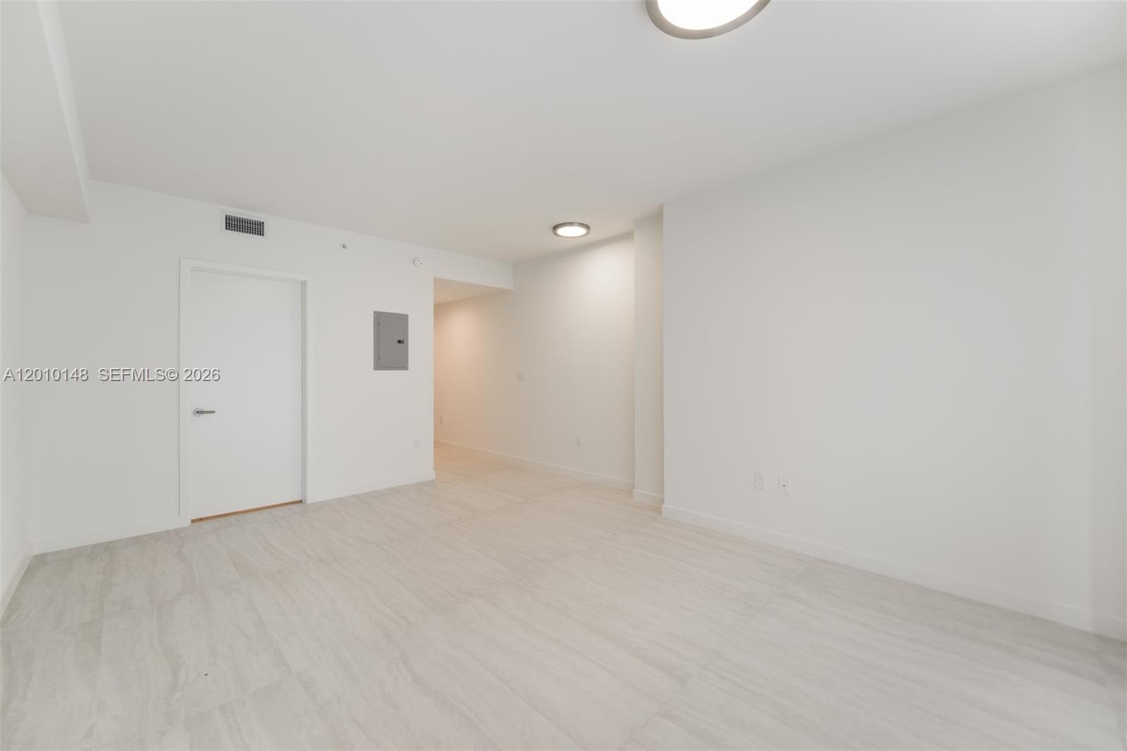 An empty room features white walls, light-colored tile flooring, and two ceiling light fixtures — 77 SE 5 Street # 2604, Miami FL 33131, MIAMI, FL