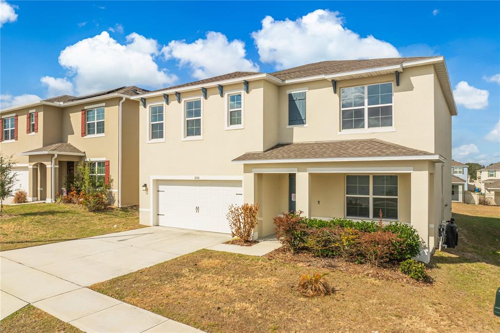 An entryway features a white front door, tiled flooring, and an adjacent carpeted living area — 2340 CANYON OAK DRIVE, DAVENPORT, FL