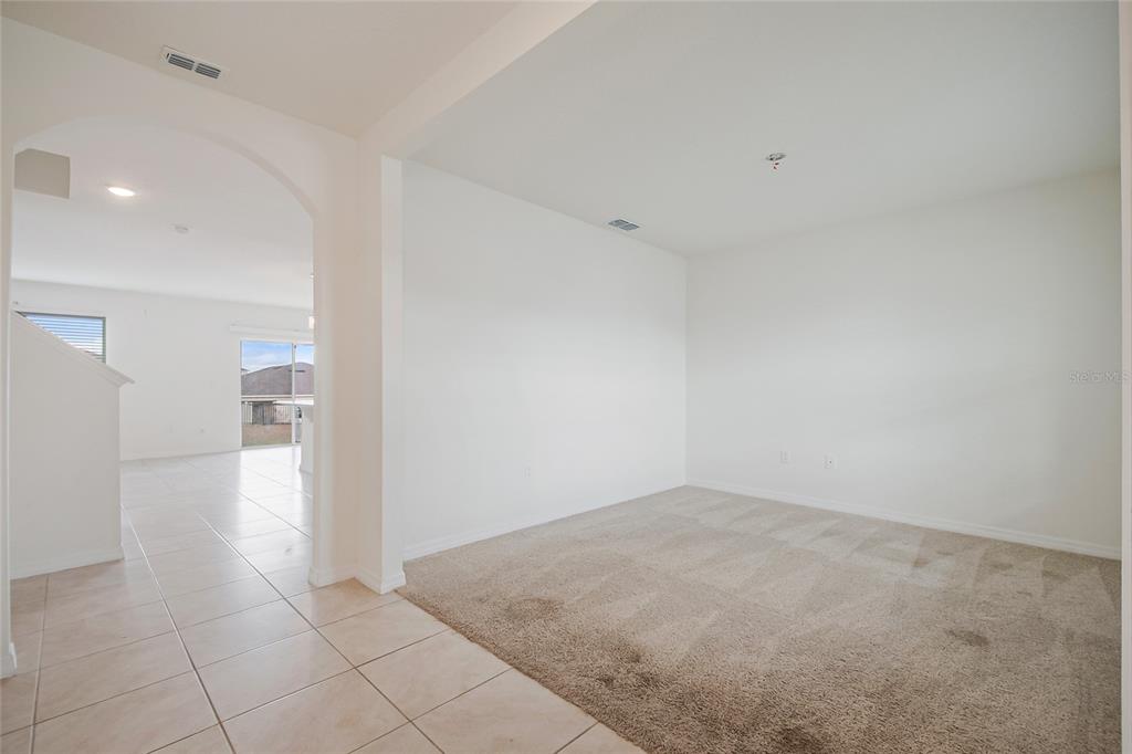 An empty room with beige carpet, white walls, and a large window with white blinds — 2340 CANYON OAK DRIVE, DAVENPORT, FL