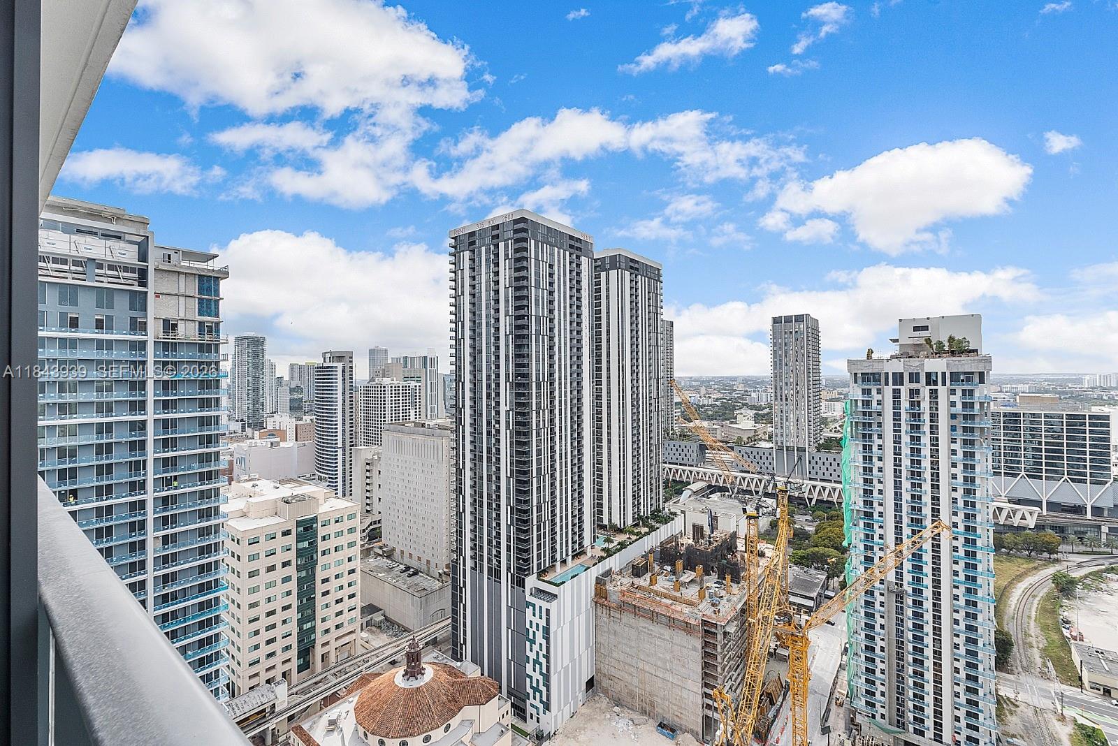 An elevated view of a dense urban skyline featuring multiple high-rise buildings and construction cranes — 159 NE 6th St # 2903, Miami FL 33132, MIAMI, FL