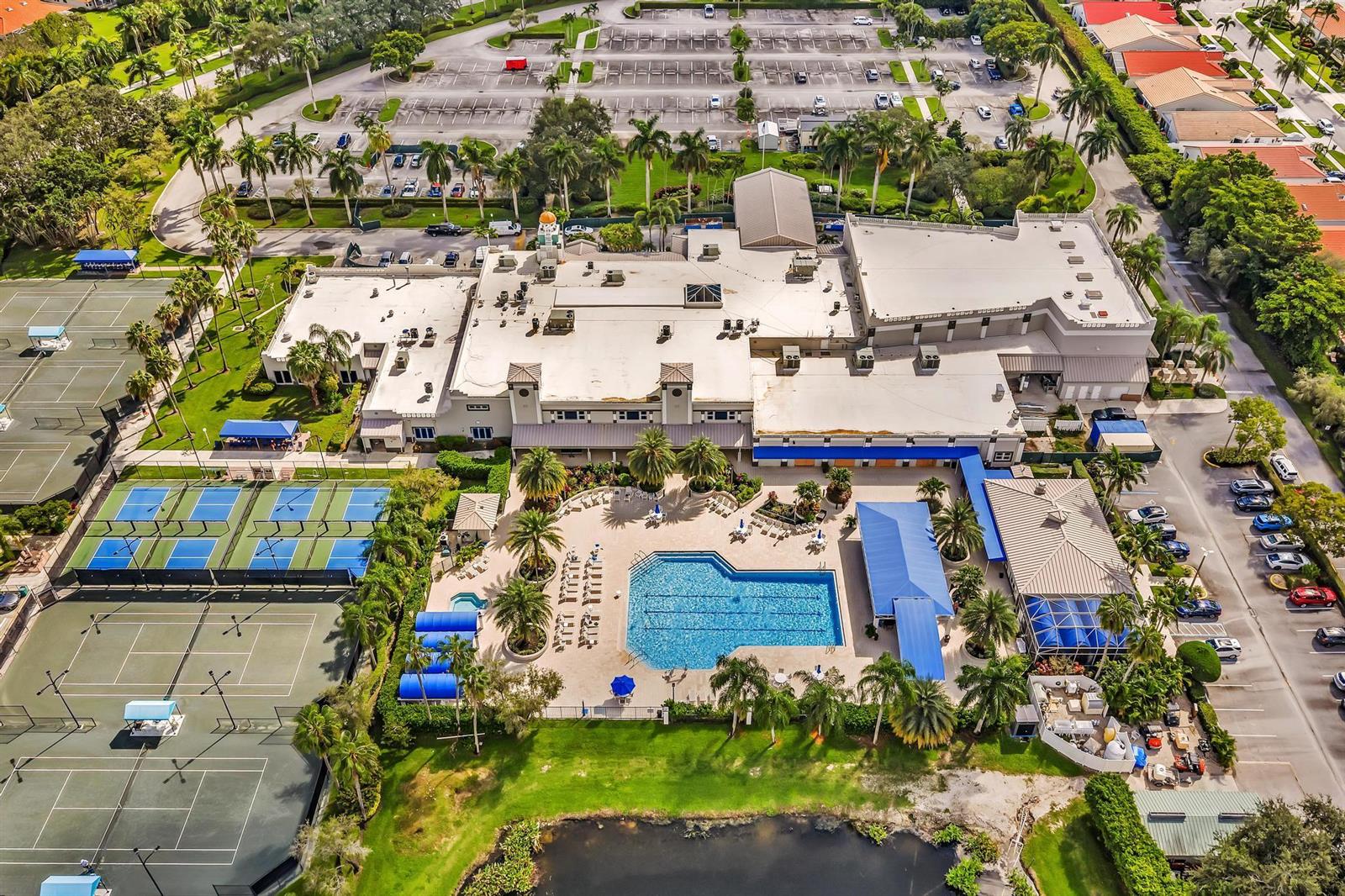 An aerial view shows a large building complex with tennis courts, a swimming pool, and parking — 9589 Shadybrook Drive # 201, Boynton Beach FL 33437, BOYNTON BEACH, FL