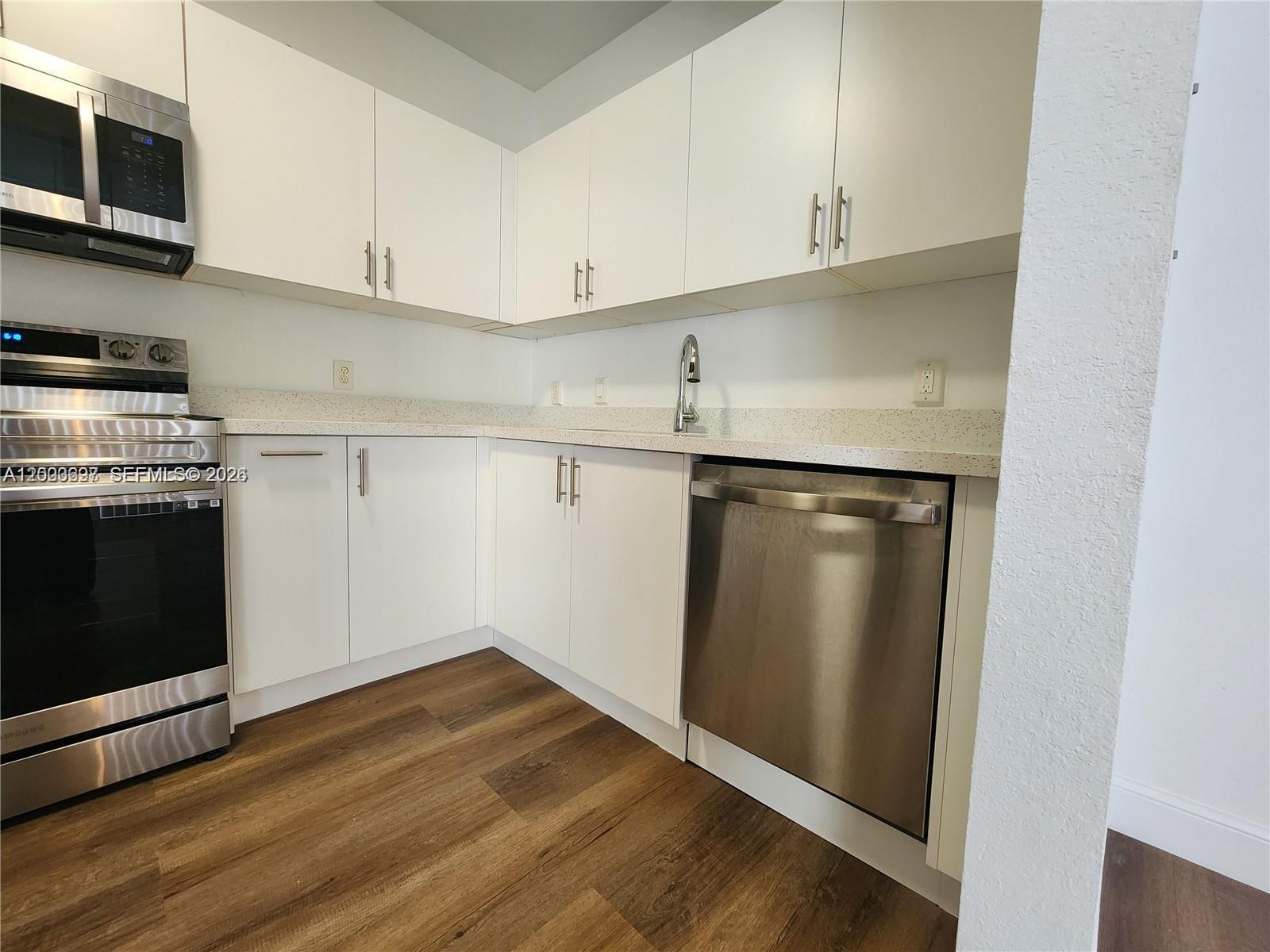 A kitchen features white cabinets, stainless steel appliances, and light-colored speckled countertops — 15798 SW 40th St # 72, Miramar FL 33027, MIRAMAR, FL