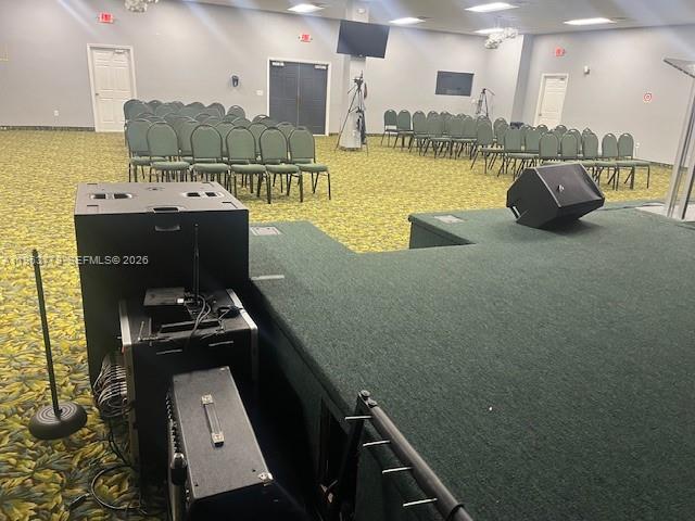 A large room features a stage with audio equipment and rows of chairs on carpet — 4257 NW 12 ST, Lauderhill FL 33313, LAUDERHILL, FL