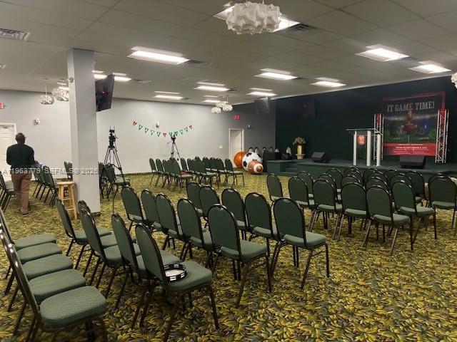A large room features rows of green chairs, a stage with a podium, and patterned carpeting — 4257 NW 12 ST, Lauderhill FL 33313, LAUDERHILL, FL