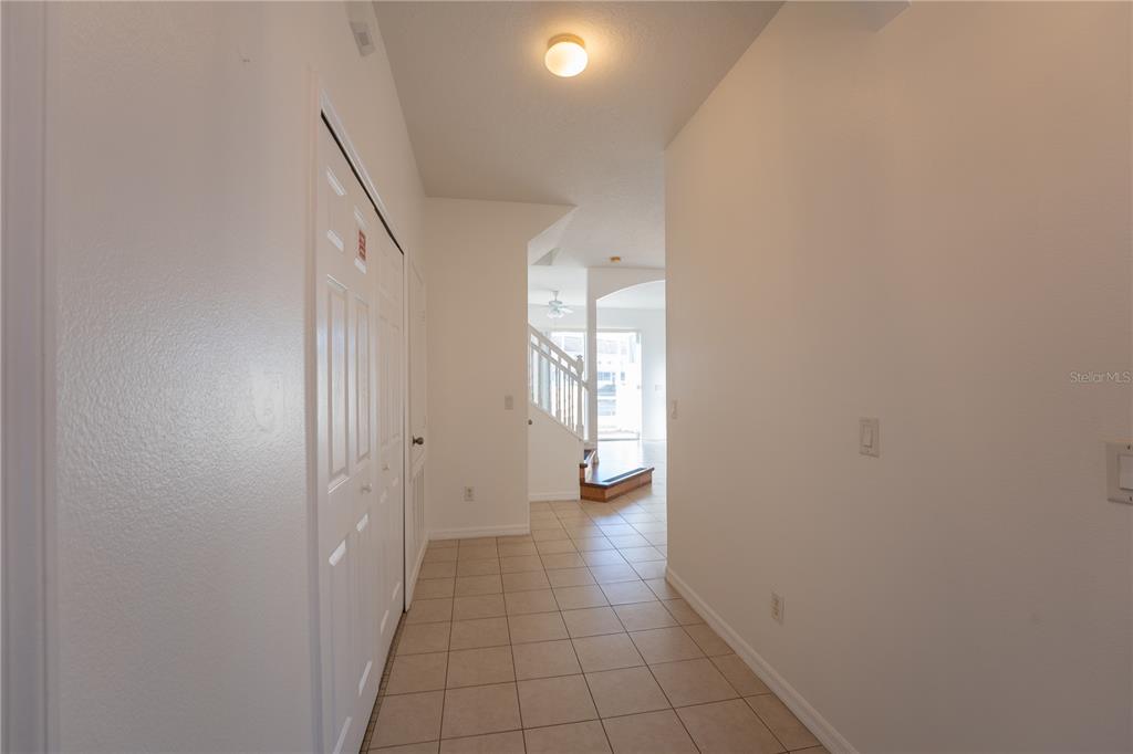 A tiled entryway leads to a staircase and a doorway with a view outside — 4712 HEMINGWAY HOUSE STREET, KISSIMMEE, FL