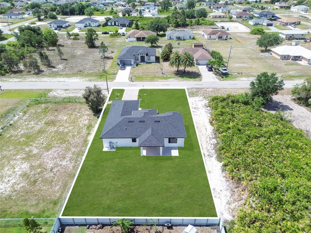 An aerial view shows a single-story house with a dark roof on a large lot — 2606 40TH ST STREET, LEHIGH ACRES, FL