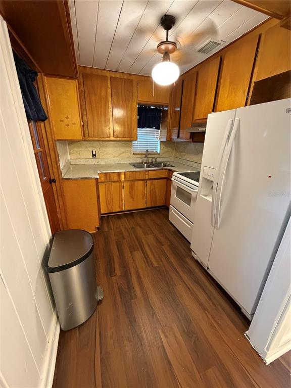A kitchen features wood cabinets, stainless steel appliances, and wood-look flooring — 118 E PINE STREET, DAVENPORT, FL
