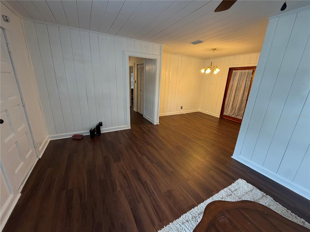 A room with white vertical wood-paneled walls and dark wood-look flooring — 118 E PINE STREET, DAVENPORT, FL