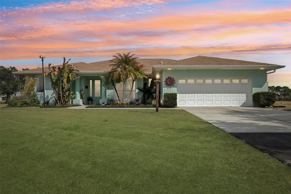 A single-story house with light green siding, a two-car garage, and a palm tree — 803 BEL AIR STAR PARKWAY, SARASOTA, FL