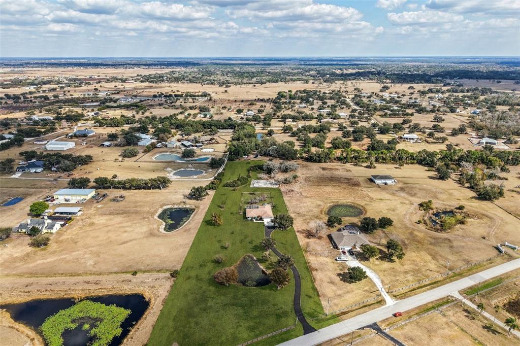 An aerial view shows a rural property with a house, driveway, and several small ponds — 803 BEL AIR STAR PARKWAY, SARASOTA, FL