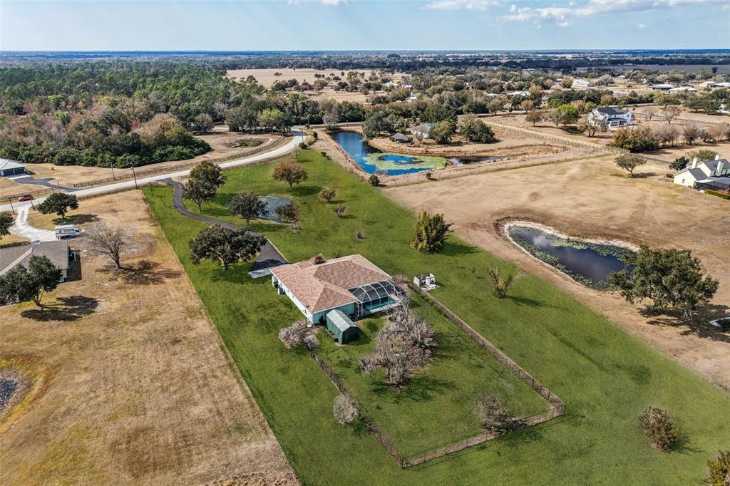 An aerial view shows a house with a pool and fenced yard on a rural lot — 803 BEL AIR STAR PARKWAY, SARASOTA, FL
