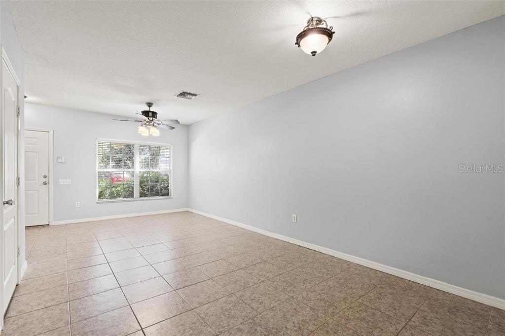 An empty room with light-colored walls, tile flooring, a ceiling fan, and a window — 2369 LAKE WOODBERRY CIRCLE, BRANDON, FL